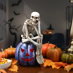 11 in. Halloween Skeleton Resting on a Purple Galaxy Jack O Lantern